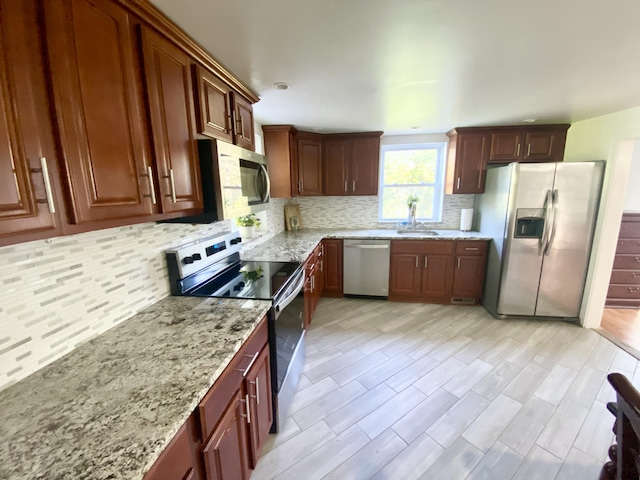 244 Learn Rd, Tannersville, PA 18372 - kitchen featuring appliances with stainless steel finishes, a sink, decorative backsplash, and light stone countertops