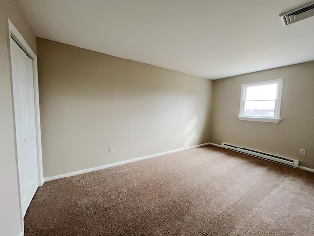 unfurnished bedroom featuring visible vents, a baseboard heating unit, a closet, carpet floors, and baseboards