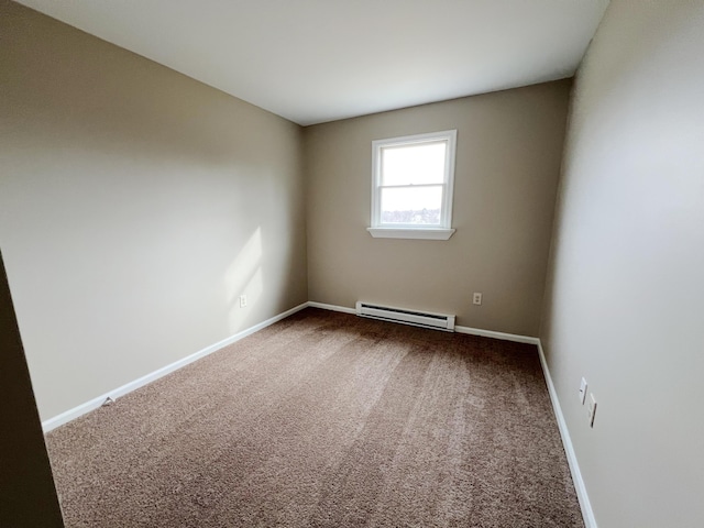 empty room featuring baseboards, baseboard heating, and carpet floors