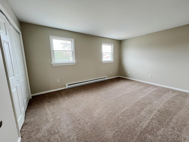 unfurnished bedroom with a baseboard heating unit, baseboards, a closet, and carpet flooring