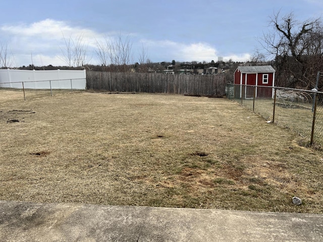 view of yard with a shed, an outdoor structure, and fence