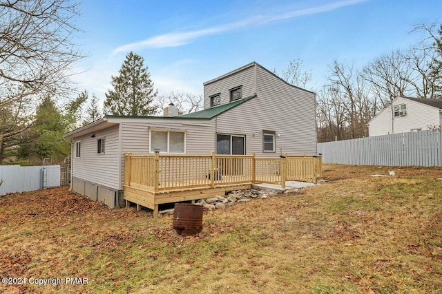 back of house featuring a chimney, fence, and a deck