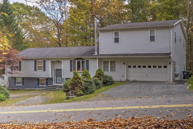 view of front of home with gravel driveway and an attached garage