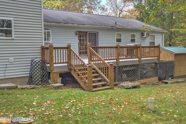 rear view of house with a wall mounted air conditioner, a lawn, and a wooden deck