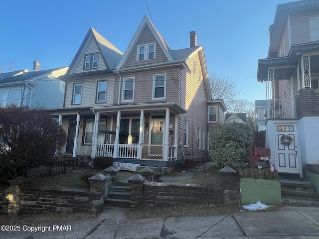 view of front of house featuring covered porch and a chimney