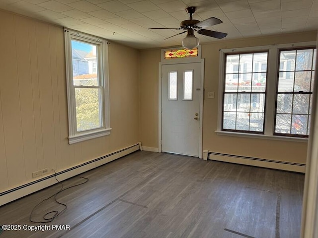 doorway featuring ceiling fan, baseboard heating, and wood finished floors