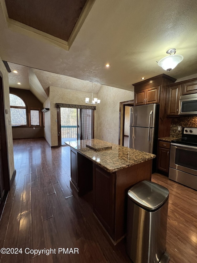 kitchen featuring stone counters, a center island, dark wood-style flooring, decorative backsplash, and appliances with stainless steel finishes