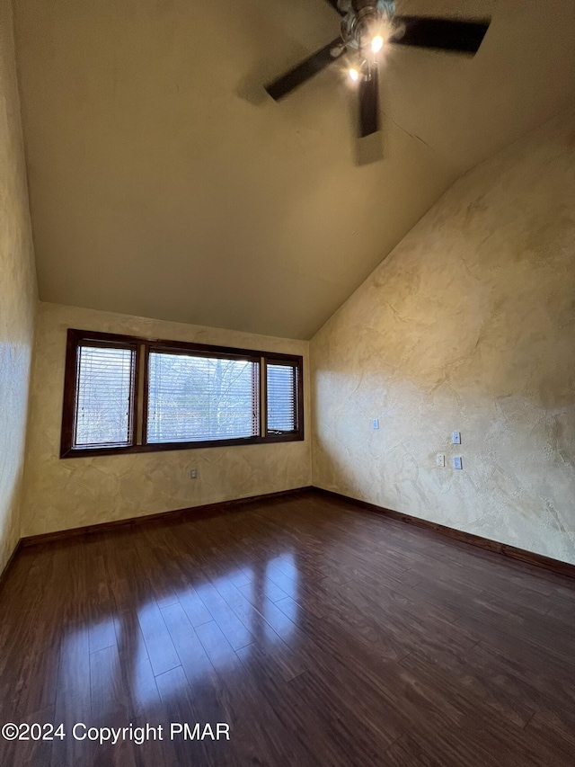 unfurnished room with lofted ceiling, wood finished floors, a ceiling fan, and baseboards