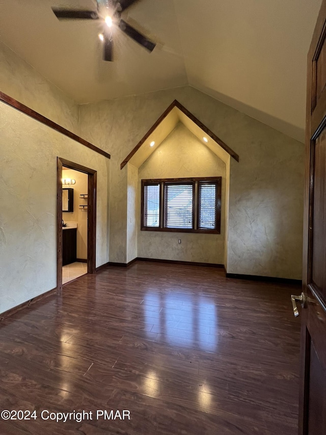 empty room with ceiling fan, a textured wall, high vaulted ceiling, wood finished floors, and baseboards