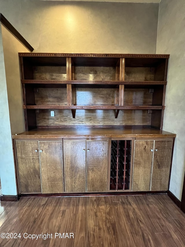 bar featuring dark wood-style flooring and baseboards