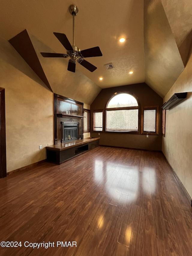 unfurnished living room with vaulted ceiling, ceiling fan, wood finished floors, and visible vents