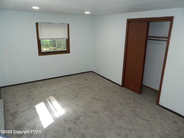 unfurnished bedroom with carpet, a closet, baseboards, and recessed lighting