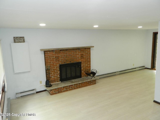 unfurnished living room with wood finished floors, baseboard heating, a baseboard radiator, and a fireplace