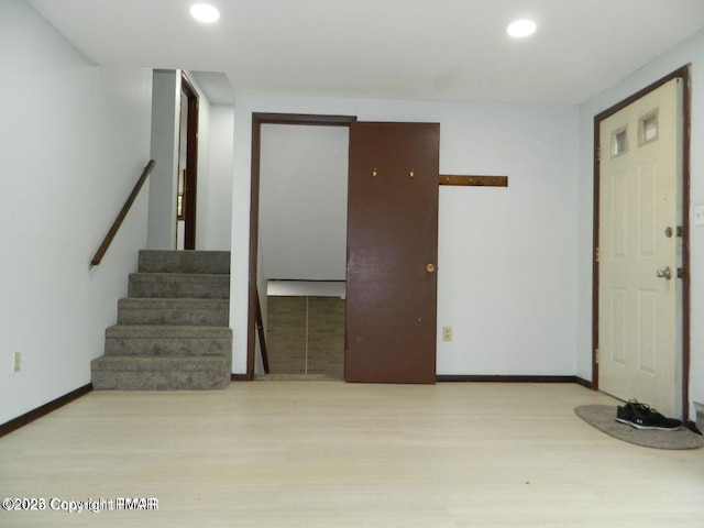 foyer featuring stairs, baseboards, wood finished floors, and recessed lighting