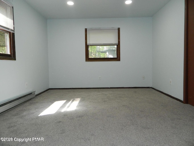 carpeted empty room with baseboards, a baseboard heating unit, and recessed lighting