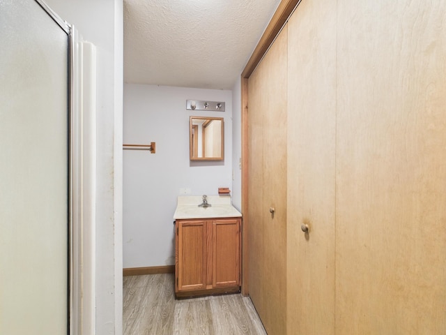 114 Oswayo Dr, Pocono Lake, PA 18347 - full bath with wood finished floors, a textured ceiling, vanity, a shower with shower door, and baseboards