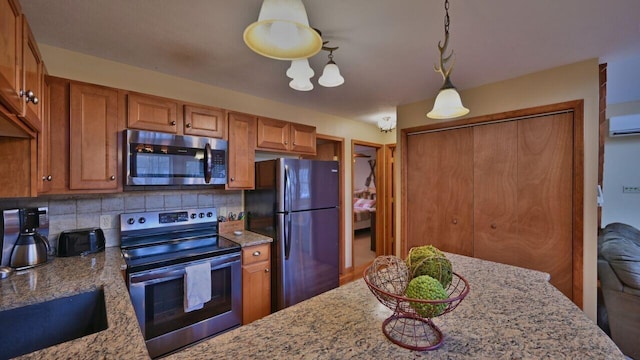 kitchen featuring tasteful backsplash, stainless steel appliances, and brown cabinets