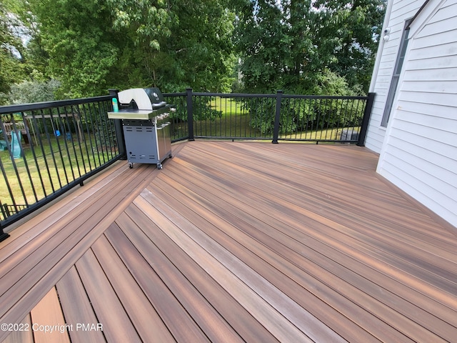 wooden deck with grilling area and a yard