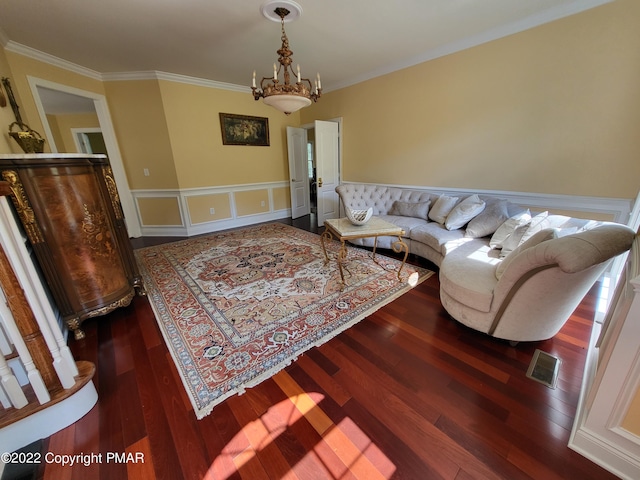 living area with ornamental molding, wood finished floors, visible vents, and a notable chandelier