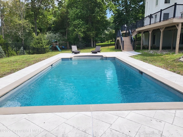 view of swimming pool featuring a fenced backyard, stairs, a deck, and a yard