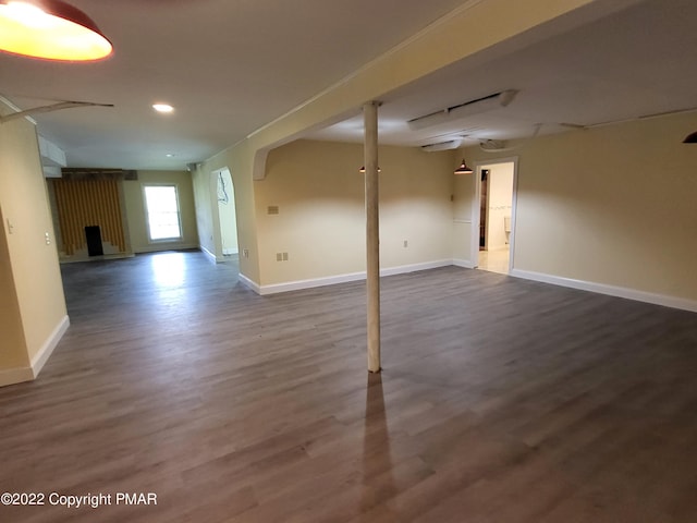 below grade area with recessed lighting, dark wood finished floors, and baseboards