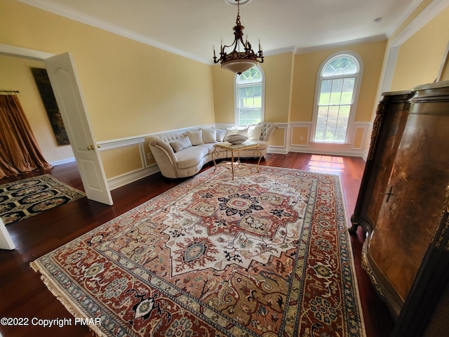 interior space with ornamental molding, a decorative wall, wood finished floors, and wainscoting