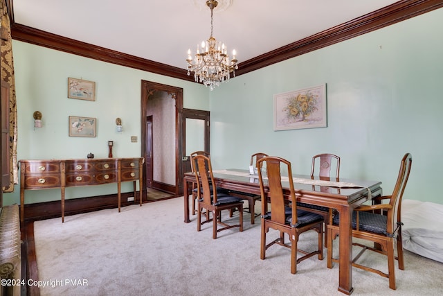 dining area with ornamental molding, light carpet, a notable chandelier, and baseboards