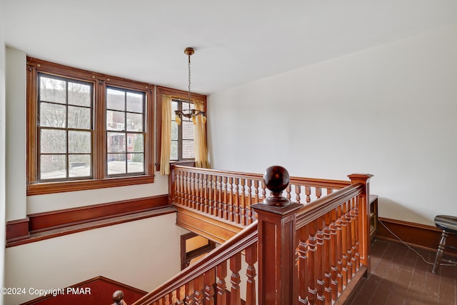 staircase featuring baseboards and wood finished floors