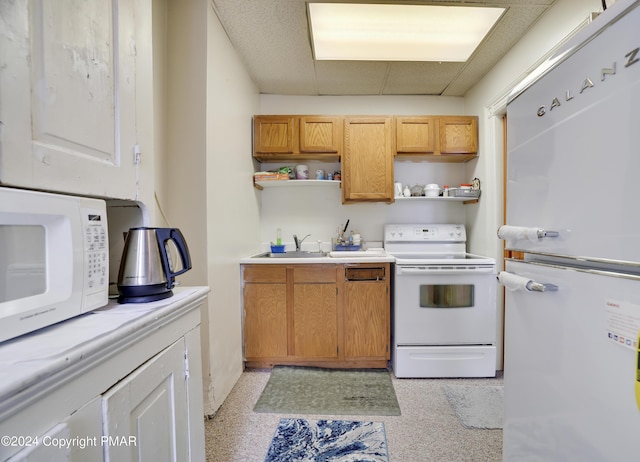 kitchen featuring white appliances, light countertops, a drop ceiling, and open shelves