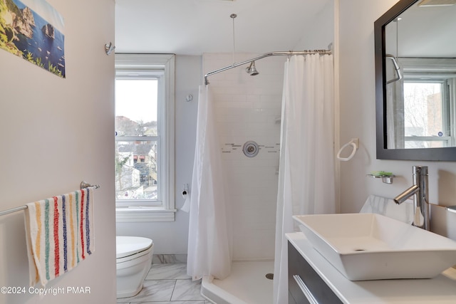 bathroom featuring plenty of natural light, marble finish floor, a sink, and toilet