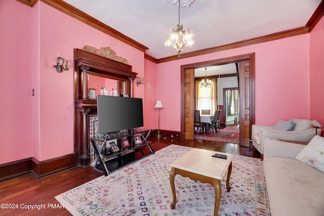 living room featuring an inviting chandelier, wood-type flooring, baseboards, and crown molding