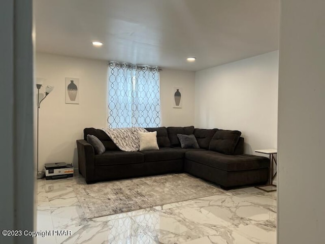 living area with recessed lighting and marble finish floor