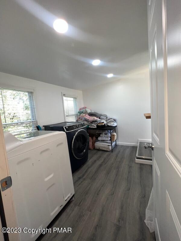 laundry area featuring plenty of natural light, separate washer and dryer, dark wood finished floors, and laundry area