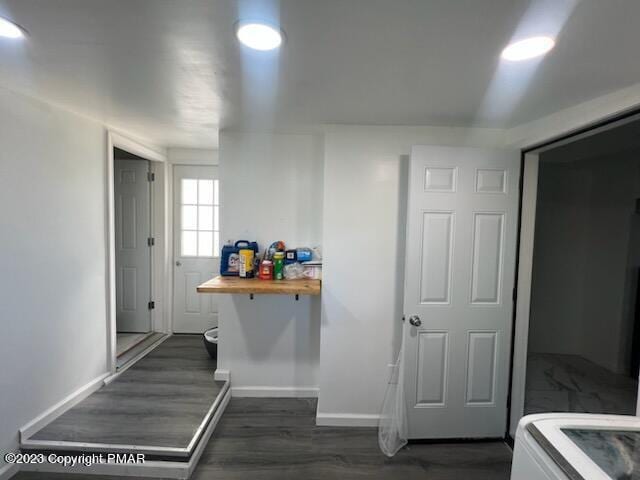 corridor with dark wood-style floors and baseboards