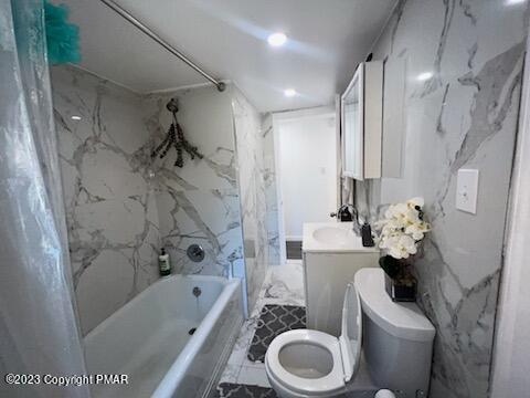 bathroom with shower / bathtub combination with curtain, toilet, and vanity