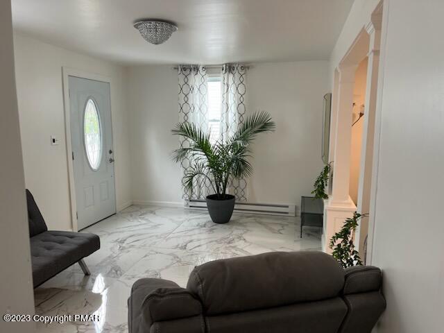 foyer entrance featuring marble finish floor and baseboard heating