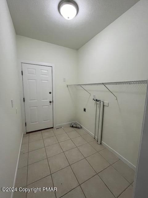 laundry room featuring laundry area, baseboards, electric dryer hookup, and a textured ceiling