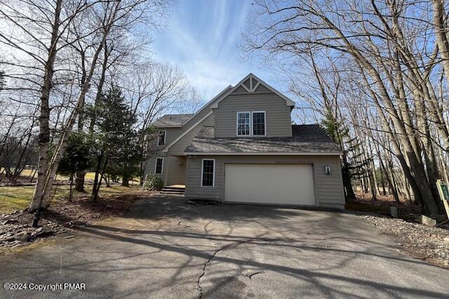 view of front of home with an attached garage and aphalt driveway