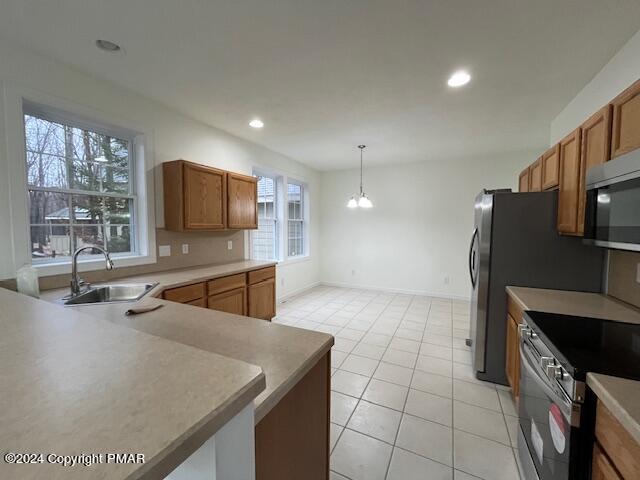 kitchen with brown cabinetry, stainless steel electric range, a sink, and recessed lighting