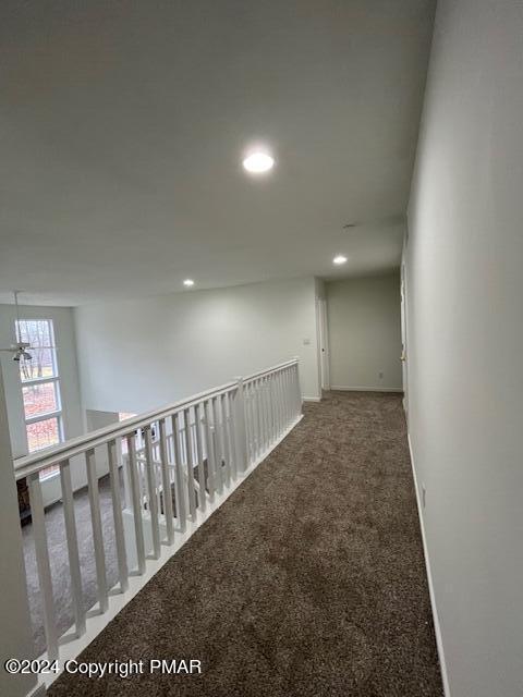 hallway featuring baseboards, carpet floors, and recessed lighting