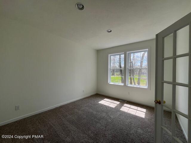 carpeted empty room featuring baseboards