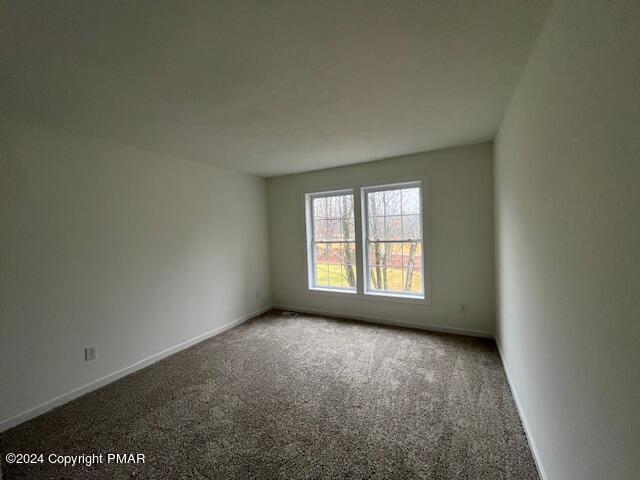 carpeted empty room with baseboards