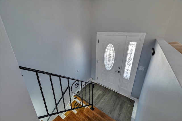 foyer entrance with stairway, wood finished floors, and baseboards