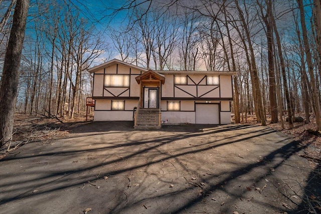 view of front of house featuring aphalt driveway, an attached garage, and stucco siding