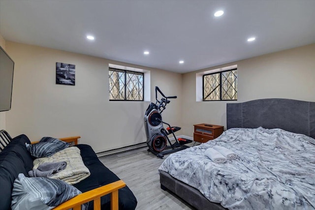 bedroom featuring a baseboard heating unit, recessed lighting, and light wood finished floors