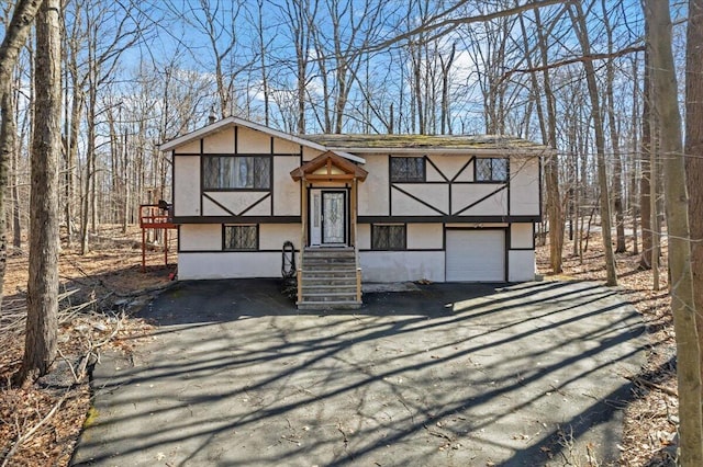 view of front of property featuring stucco siding, an attached garage, and driveway