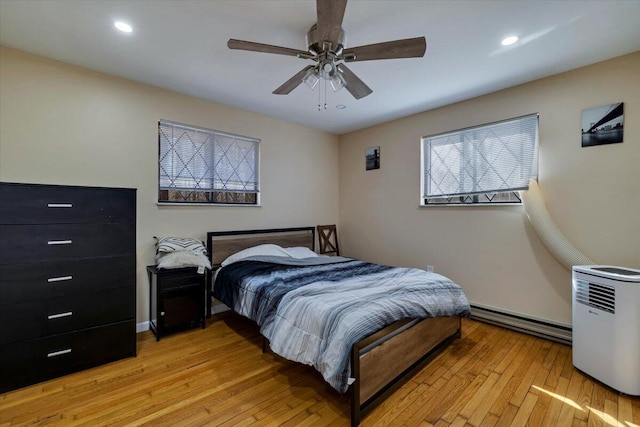 bedroom featuring a baseboard heating unit, light wood-style flooring, recessed lighting, and ceiling fan