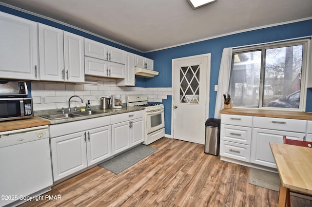 kitchen featuring light wood finished floors, butcher block counters, a sink, white appliances, and under cabinet range hood