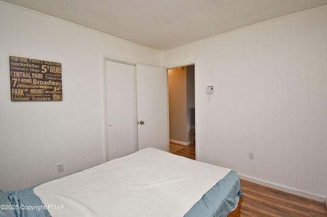 bedroom featuring a closet, baseboards, and wood finished floors