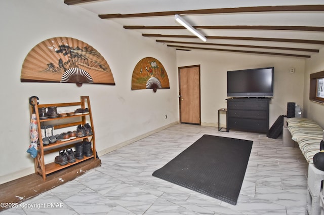 living area with vaulted ceiling with beams, marble finish floor, and baseboards